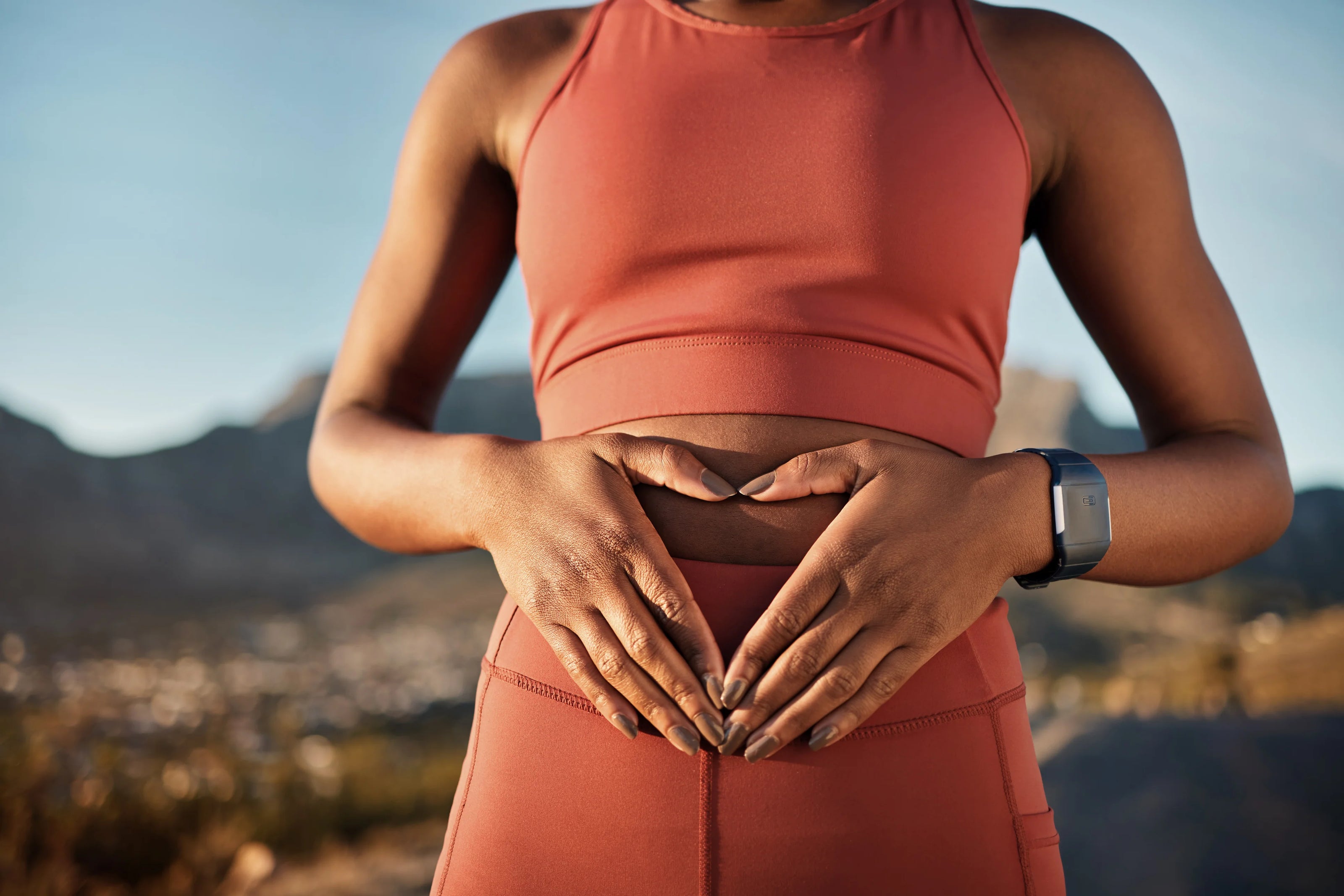 Women in red activewear holding stomach